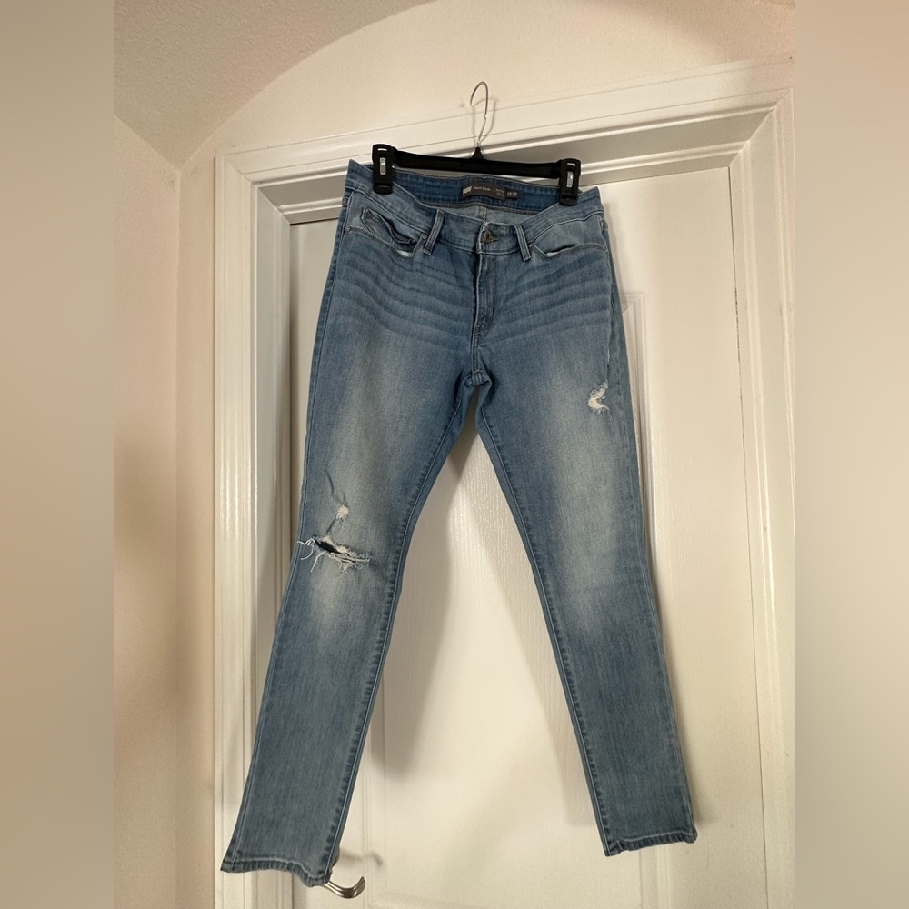 Demi curve mid rise skinny jeans light wash, rip on right knee.